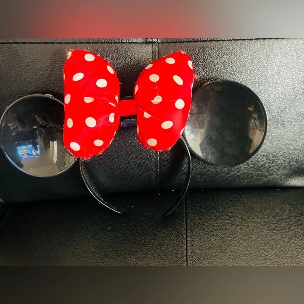 Minnie Mouse ear headband with a red and white polka dot bow.